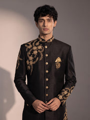 Black indowestern close-up showing gold zardozi embroidery, mandarin collar and gold buttons
